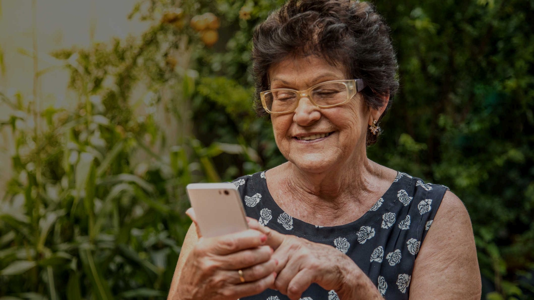 Na imagem há uma consumidora olhando para o aplicativo Enel GO no celular